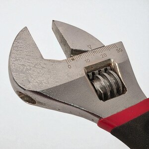 Adjustable wrench with measurement scale on a white background