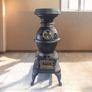 May include: A black antique cast iron stove with ornate detailing. The stove has a round body, a decorative wheel, and a small door. It stands on four decorative legs and is likely used for heating.