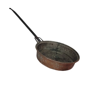 May include: An antique copper pan with a long, black handle. The pan has an oval shape and a dark interior, showing signs of age and use. The handle is attached to the pan with a metal bracket.