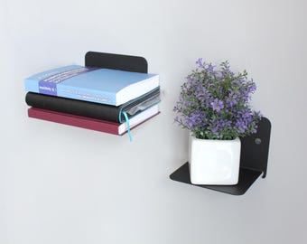 Libreria sospesa in metallo dal design minimalista: soluzione moderna e industriale per riporre i libri.
