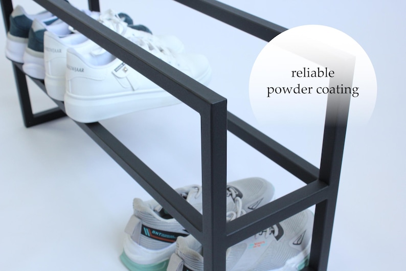 Op de afbeelding: Een zwart metalen schoenenrek met een rechthoekig frame en een matte afwerking. Het rek bevat verschillende paren sportschoenen op twee niveaus. Een cirkelvormige afbeelding aan de rechterkant bevat de tekst reliable powder coating.