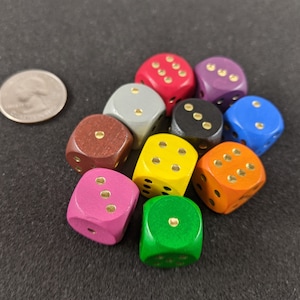 May include: A set of ten wooden dice in various colors, including red, purple, blue, gray, brown, yellow, orange, pink, and green. Each die has gold-colored dots.