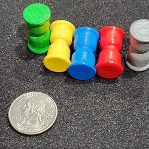 May include: Five wooden hourglass-shaped game pieces in green, yellow, blue, red, and gray.