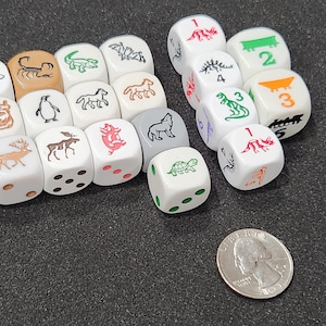May include: A set of 16 white dice with different animal and number illustrations. The dice are arranged in a semi-circle on a black surface.
