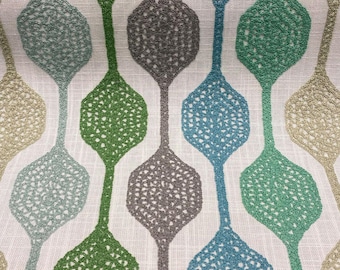 Könnte beinhalten: Ein weißer Stoff mit einem sich wiederholenden Muster aus grünen, blauen und grauen Tropfenformen. Die Tropfenformen haben ein zartes, durchbrochenes Design.