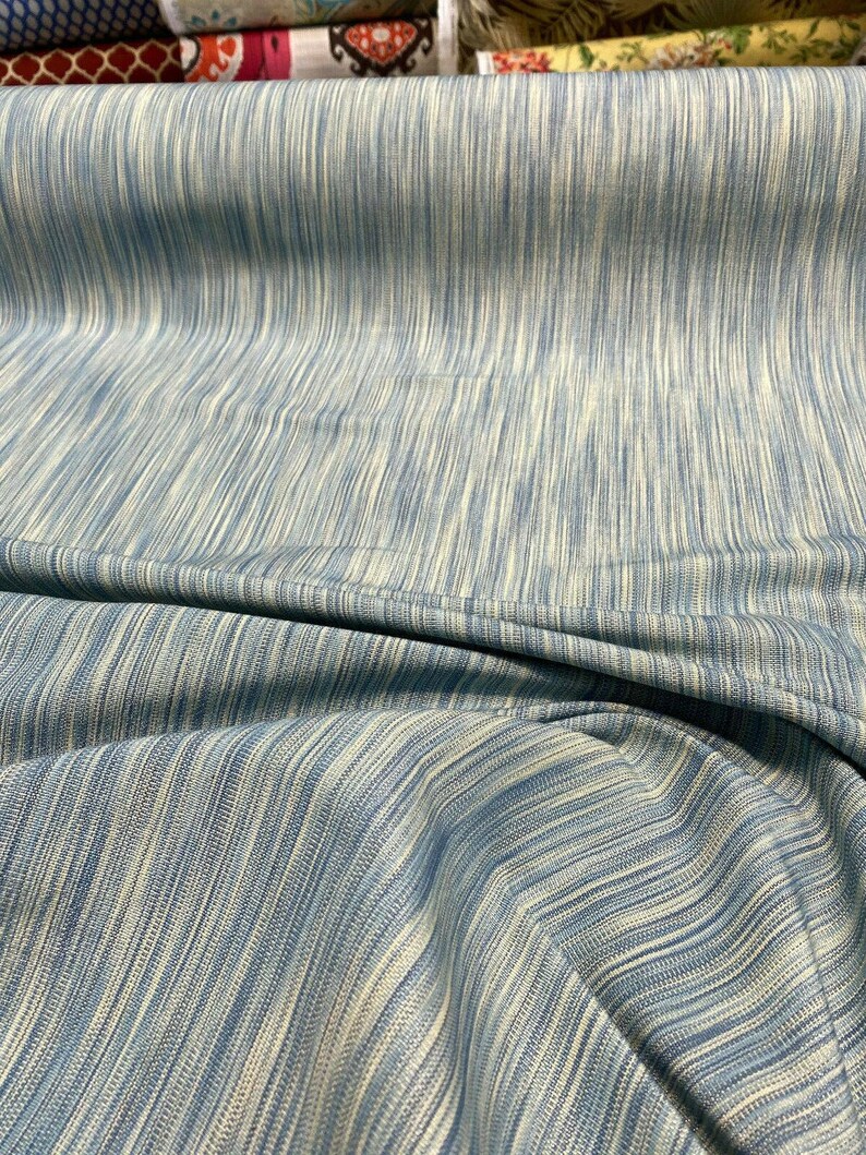 May include: A blue and white striped fabric with a subtle sheen. The fabric is woven with a fine texture and has a soft, drapey feel.