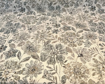 May include: A white fabric with a floral pattern in shades of gray and brown. The flowers are stylized and have a distressed look.