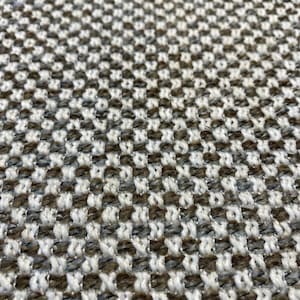 Pode incluir: Close-up de um tecido tecido com um padrão xadrez em tons de marrom, branco e cinza.