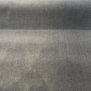 Puede incluir: Primer plano de una tela gris texturizada con un sutil patrón tejido.