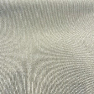 Puede incluir: Primer plano de una tela beige con un sutil patr&oacute;n de espiga blanca. La tela tiene una textura lisa y una superficie ligeramente texturizada.