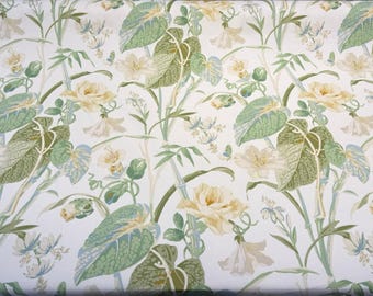 May include: A white fabric with a green and white floral pattern. The pattern features large leaves, flowers, and vines.
