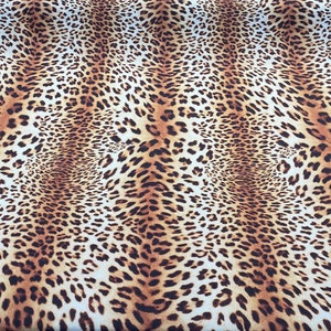 May include: A brown and white fabric with a leopard print pattern.