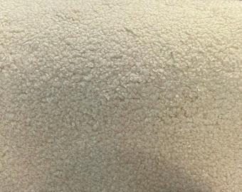 May include: Close-up of a soft, white, fluffy fabric with a textured surface. The fabric has a fuzzy, plush appearance.