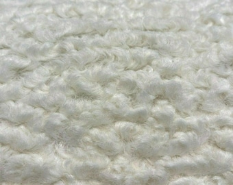 May include: Close-up of a white fluffy fabric with a soft, textured surface.