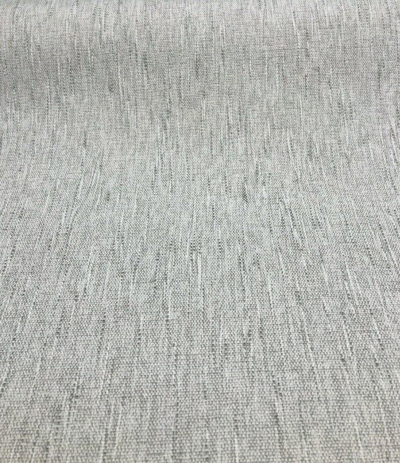 May include: Close-up of a light gray fabric with a subtle woven texture.