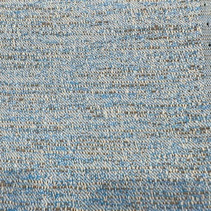 May include: Close-up of a woven fabric with a blue, white, and brown pattern. The fabric has a textured, slightly rough surface.