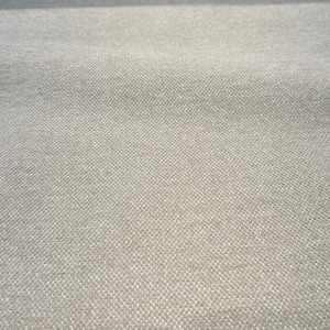 Puede incluir: Primer plano de una tela gris claro con una textura tejida sutil.