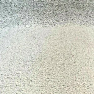 May include: Close-up of a white, textured fabric surface. The fabric has a soft, fuzzy texture.
