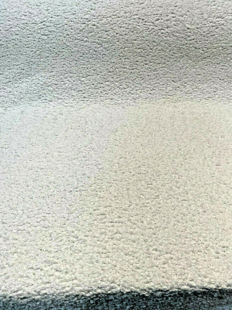 May include: Close-up of a white, textured fabric surface. The fabric has a soft, fuzzy texture.