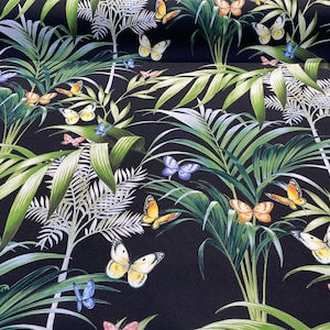 May include: A fabric with a black background featuring a tropical design. Green palm leaves and white fern-like plants are interspersed with butterflies in shades of yellow, orange, blue, and pink. The butterflies are scattered throughout the design.