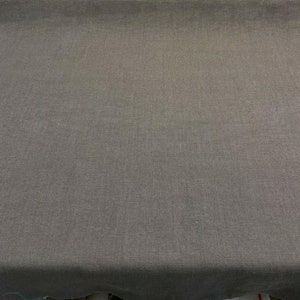 May include: A close-up of a dark gray fabric with a subtle woven texture.