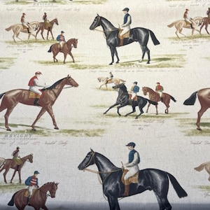 Könnte beinhalten: Cremefarbener Stoff mit einem sich wiederholenden Muster von Pferden und Jockeys in verschiedenen Posen. Die Pferde sind braun, schwarz und hellbraun, die Jockeys tragen farbenfrohe Reitseide. Das Design hat ein Vintage-Equestrian-Thema.