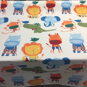May include: White fabric with a repeating pattern of colourful cartoon animals. The animals include a hippopotamus, a lion, a giraffe, an elephant, a monkey, and a crocodile. The animals are all wearing different clothes and accessories.