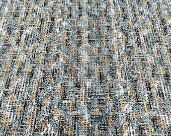 Pode incluir: Um close-up de um tecido texturizado com um padrão preto, branco, azul e dourado. O tecido tem um visual e uma sensação tecidos.