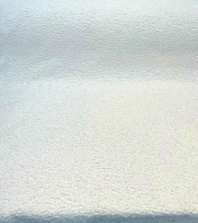 May include: A close-up of a white textured surface. The surface has a slightly grainy texture.