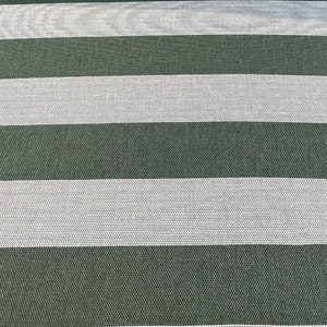 May include: A close-up of a fabric with alternating stripes of dark green and white. The fabric has a woven texture.