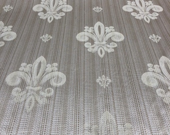 May include: Beige fabric with a white embossed pattern of fleur-de-lis. The fabric has a subtle vertical stripe pattern.