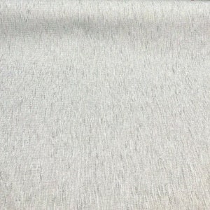 May include: A close-up of a light gray fabric with a subtle woven texture. The fabric has a slightly textured surface and a smooth, even weave.