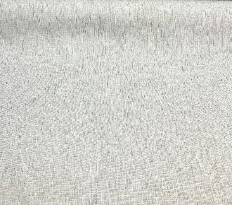 May include: A close-up of a light gray fabric with a subtle woven texture. The fabric has a slightly textured surface and a smooth, even weave.