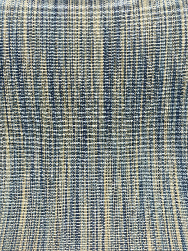 May include: A close-up of a blue and white striped fabric with a woven texture.