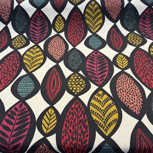 May include: A white fabric with a repeating pattern of colorful leaves. The leaves are outlined in black and filled with various patterns and colors, including red, pink, yellow, green, and blue.