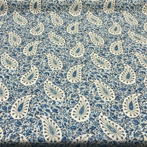 May include: White fabric with a blue paisley pattern. The paisley design is a teardrop shape with a curved tail.