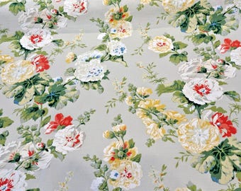 May include: A floral fabric with a repeating pattern of white, yellow, and red flowers on a light grey background.