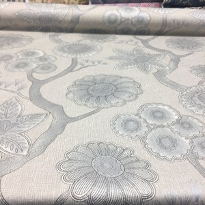Puede incluir: Primer plano de una tela gris claro con un patr&oacute;n floral plateado. La tela tiene una textura sutil y un dise&ntilde;o delicado.