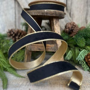 May include: Black velvet ribbon with a gold trim. The ribbon is wrapped around a wooden spool and is sitting on a wooden stool.