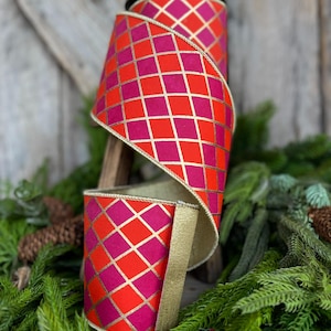 May include: A roll of decorative ribbon with a vibrant geometric pattern. The ribbon features a repeating diamond grid design in shades of red and fuchsia, accented with gold lines. The edges are trimmed with gold. Perfect for crafting and holiday decor.