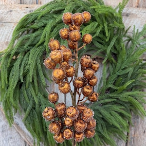 May include: A decorative floral pick featuring numerous round, copper-colored berries with a textured, glittery finish. The berries are clustered along a central brown stem, creating a dense, spherical arrangement that mimics natural fruit.
