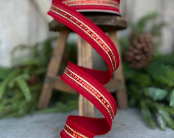 Puede incluir: Un rollo de cinta roja con detalles de lentejuelas doradas y rojas. La cinta se muestra en un remolino decorativo, mostrando su textura y diseño. Ideal para manualidades navideñas y envolver regalos.