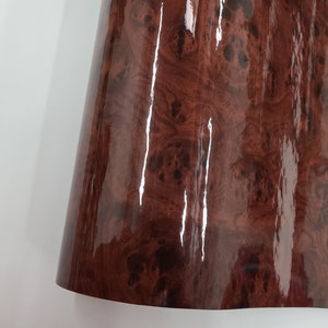 May include: A close-up of a brown woodgrain vinyl sheet with a glossy finish.
