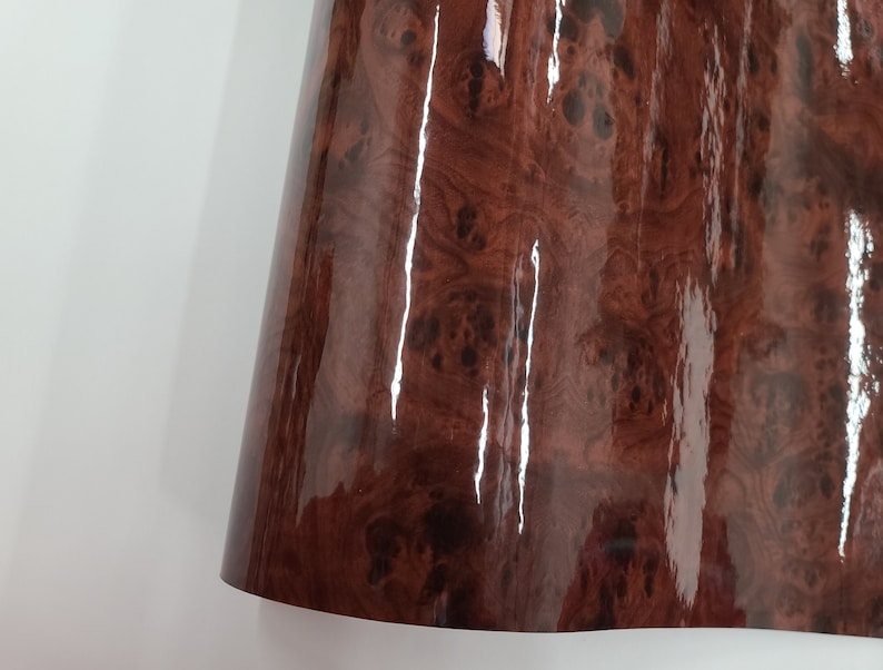 May include: A close-up of a brown woodgrain vinyl sheet with a glossy finish.