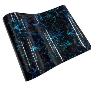 May include: A sheet of glossy black vinyl with a marbled pattern. The design features streaks of blue and teal, creating a dynamic, textured appearance. The vinyl reflects light, enhancing the visual depth of the design.