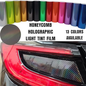 May include: A close-up of a car's taillight with a honeycomb holographic light tint film applied. The film is available in 13 colors.  The text "Honeycomb Holographic Light Tint Film" and "13 Colors Available" is visible in the image.