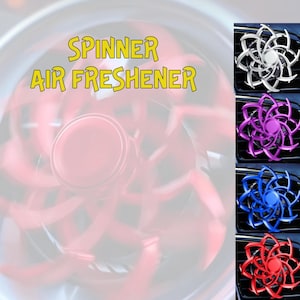 May include: A car air freshener shaped like a spinner with a silver, purple, blue, and red design. The text "Spinner Air Freshener" is displayed above the image.