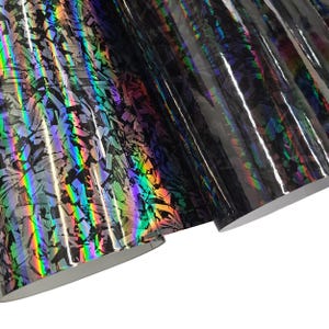 May include: Black iridescent vinyl with a shattered glass pattern. The vinyl has a holographic finish that shimmers with rainbow colors.