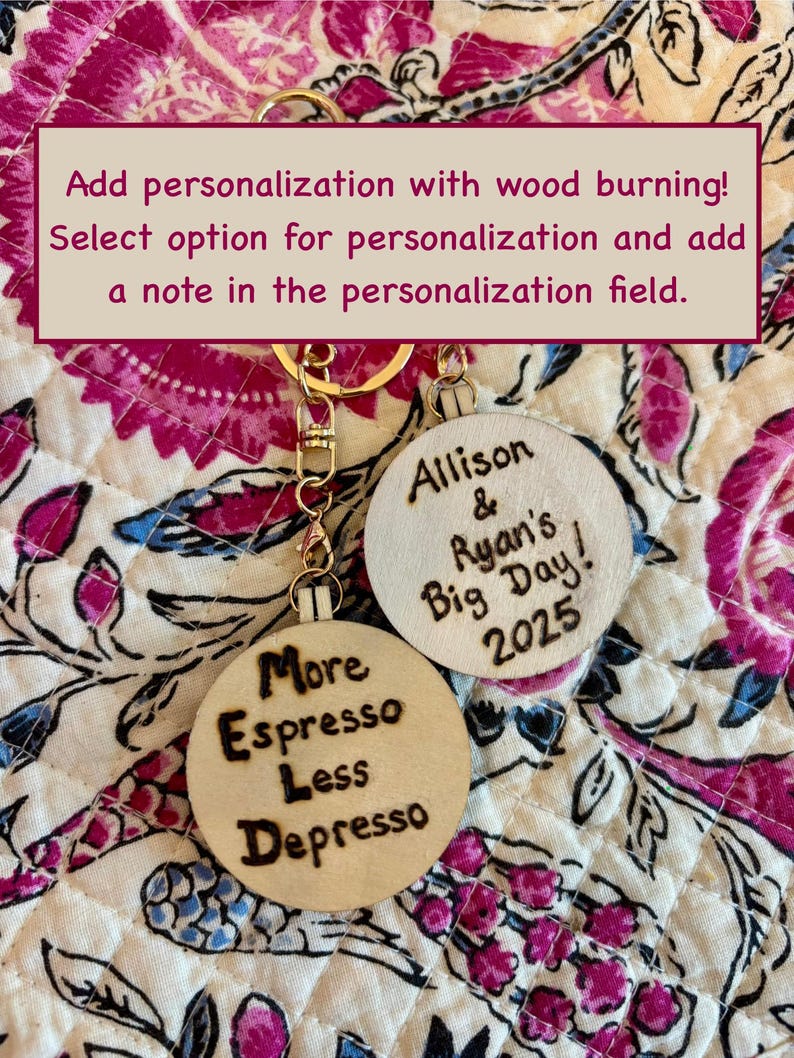 May include: Two wooden keychains with gold-colored hardware. One keychain says "More Espresso Less Depresso" in a burnt wood style. The other keychain says "Allison & Ryan's Big Day! 2025".