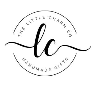 Puede incluir: Logotipo en blanco y negro para The Little Charm Co. Handmade Gifts. El logotipo presenta un c&iacute;rculo con el texto "The Little Charm Co. Handmade Gifts" alrededor del borde y las letras "lc" en una fuente estilizada en el centro.